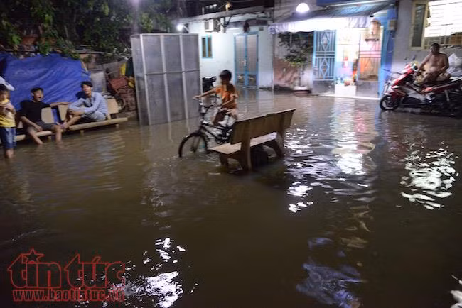 Người dân TP Hồ Chí Minh lại ‘bì bõm' trong nước triều dâng cao ảnh 4