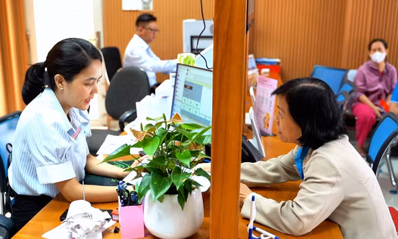 Cán bộ tại phường Hạnh Thông (TP Hồ Chí Minh) hướng dẫn người dân thực hiện thủ tục hành chính trực tuyến.