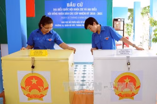 Đoàn viên thanh niên hỗ trợ công tác chuẩn bị, trang trí tại Khu vực bỏ phiếu tại Phường 16, Quận Gò Vấp. Ảnh: An Hiếu - TTXVN