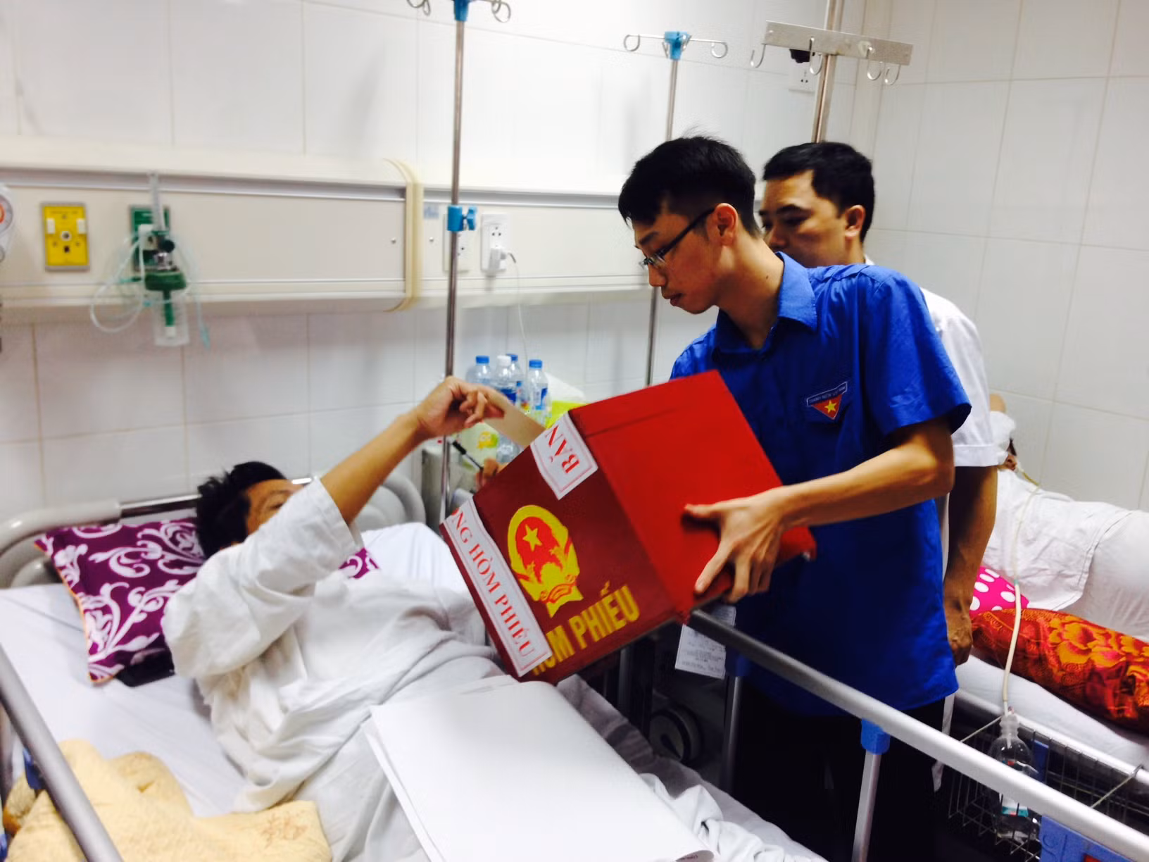 Cử tri Phạm Huy Tuy bỏ phiếu vào thùng phiếu lưu động do đơn vị bầu cử phường Hàng Bông, quận Hoàn Kiếm (Hà Nội) mang đến bệnh viện. Ảnh: Minh Nghĩa/TTXVN