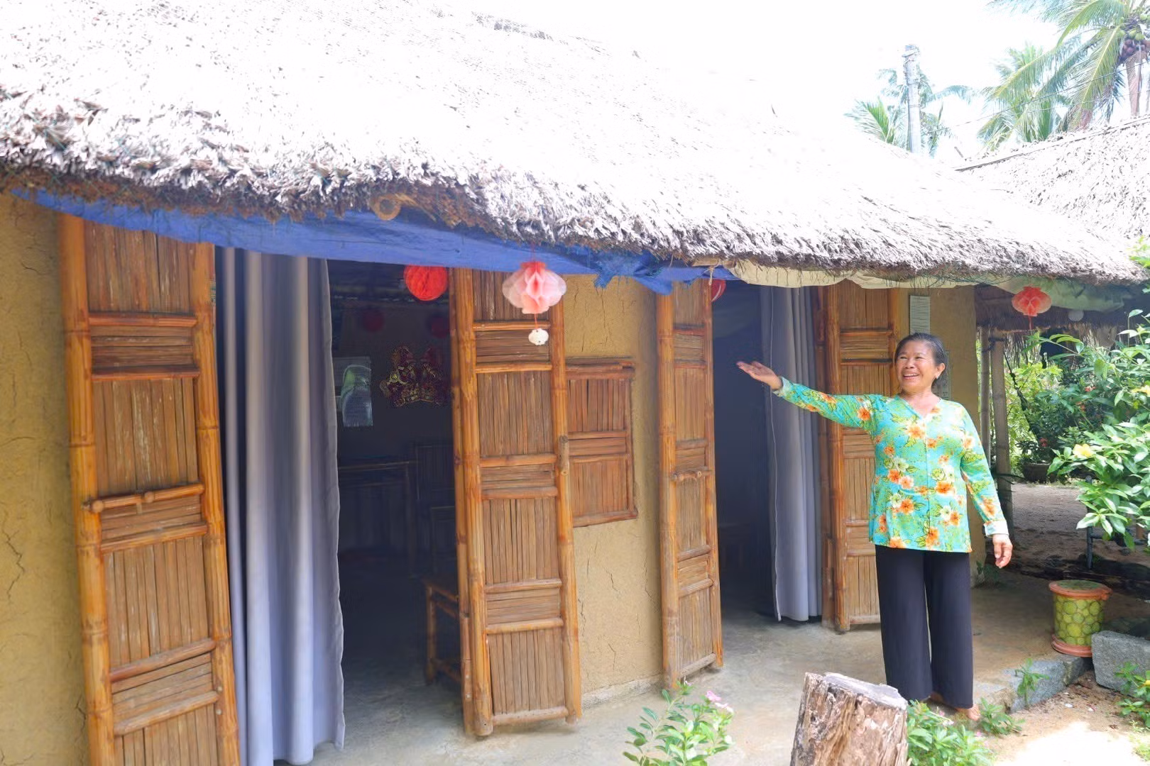 Bà Bùi Thị Sen bên ngôi nhà của mình. Ảnh: Đinh Hương/TTXVN
