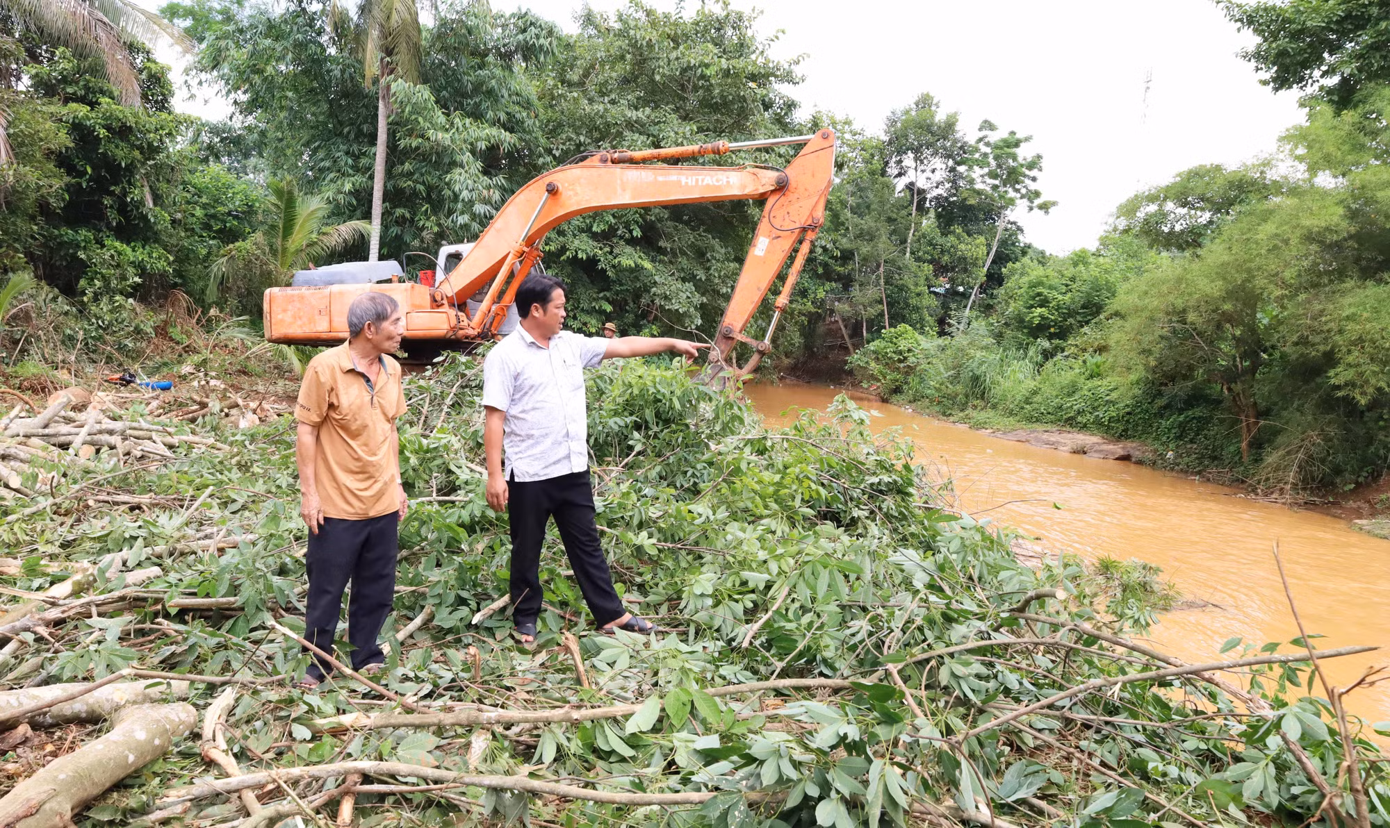 Ông Nguyễn Đức Minh (áo vàng) cho biết nhiều năm qua nước lũ thường xuyên dâng sát nhà, có năm ngập sâu khoảng một mét.