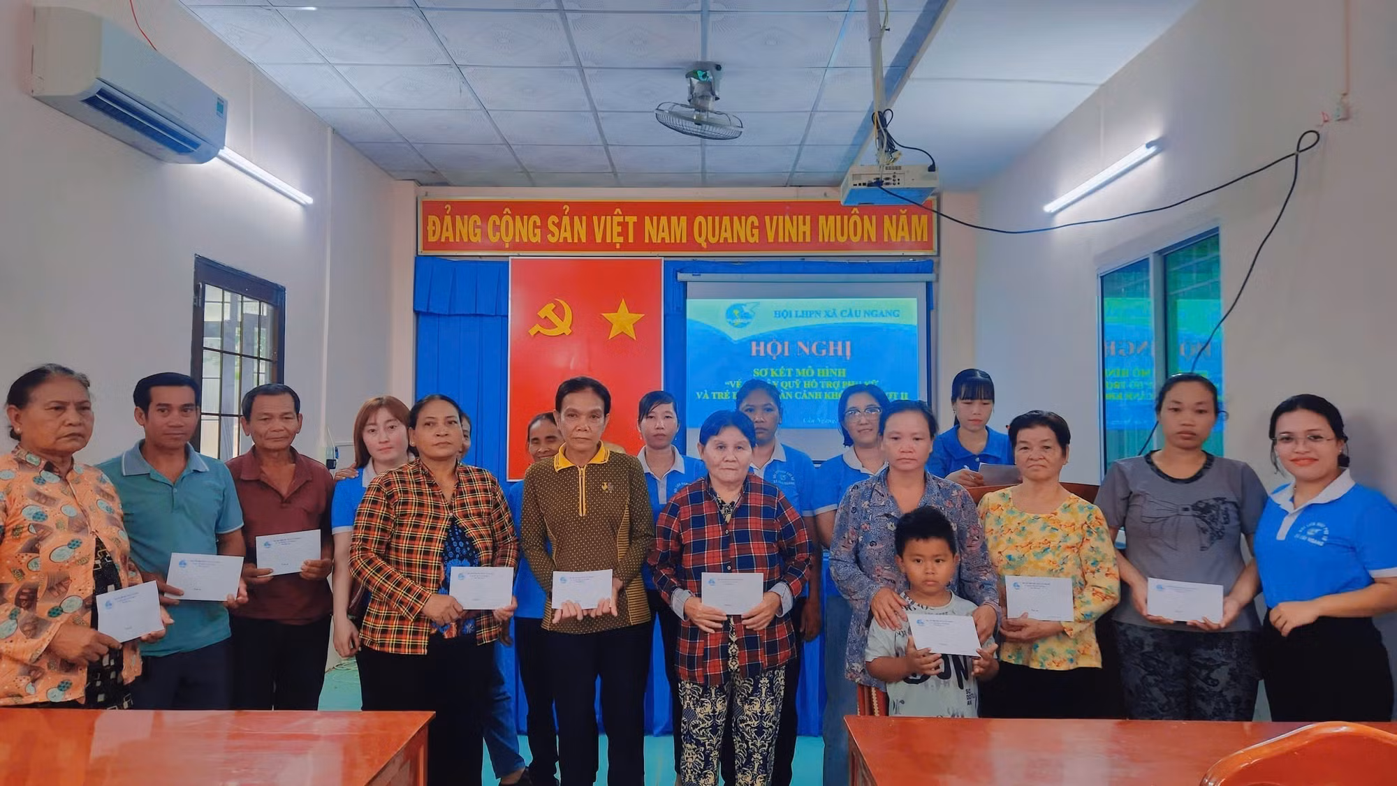 Hội Liên hiệp Phụ nữ xã Cầu Ngang trao tiền hỗ trợ phụ nữ có hoàn cảnh khó khăn từ nguồn bán vé số gây quỹ. Ảnh: TTXVN phát