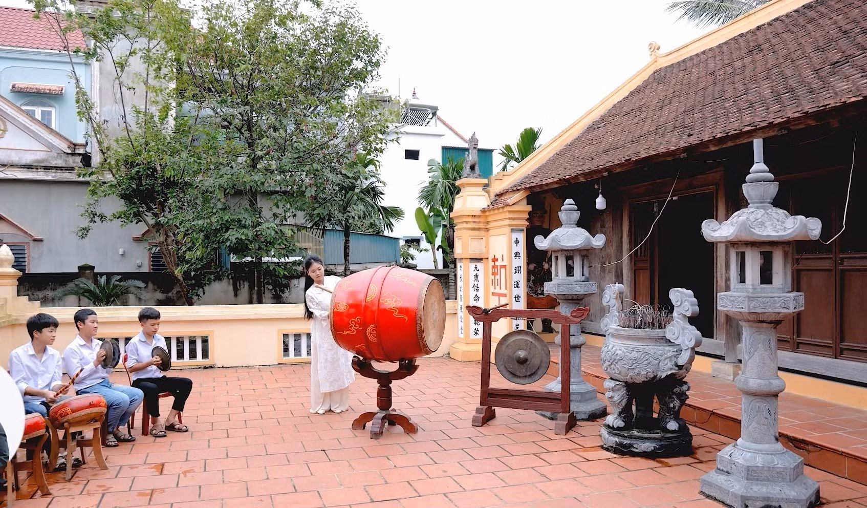 Học sinh Trường THCS Phan Đăng Lưu đánh trống tế tại nhà thờ dòng họ Phan Tất (xã Yên Thành, Nghệ An). Ảnh: TTXVN phát