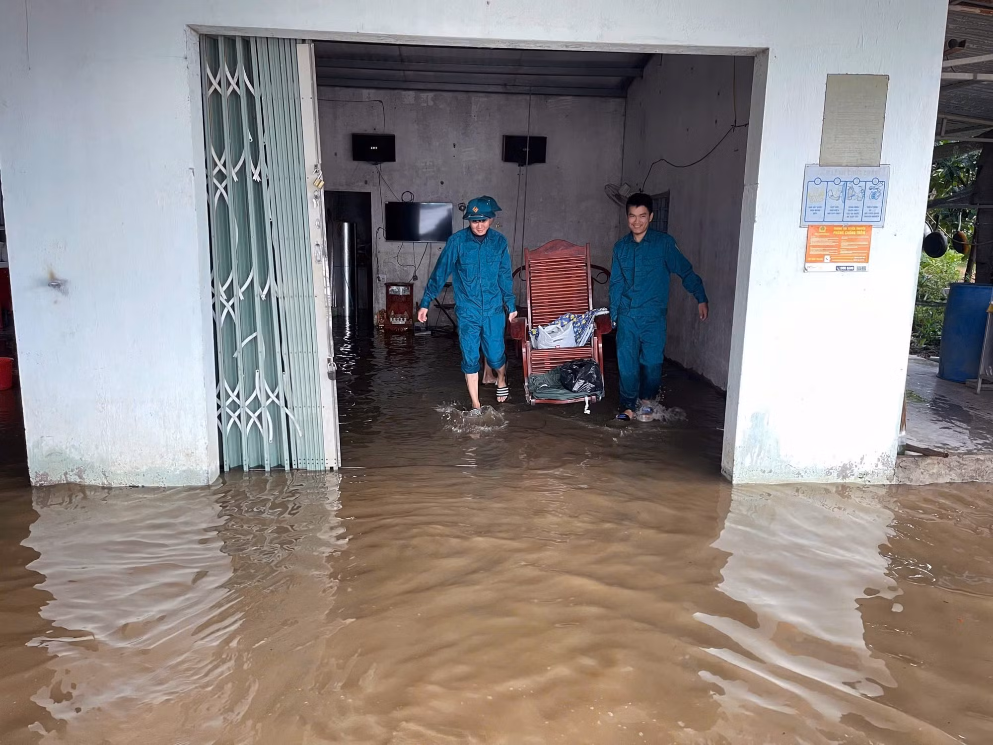 Lực lượng dân quân hỗ trợ người dân di chuyển đồ đạc khỏi vùng ngập lụt ven sông Krông Nô, tỉnh Lâm Đồng. Ảnh: TTXVN phát