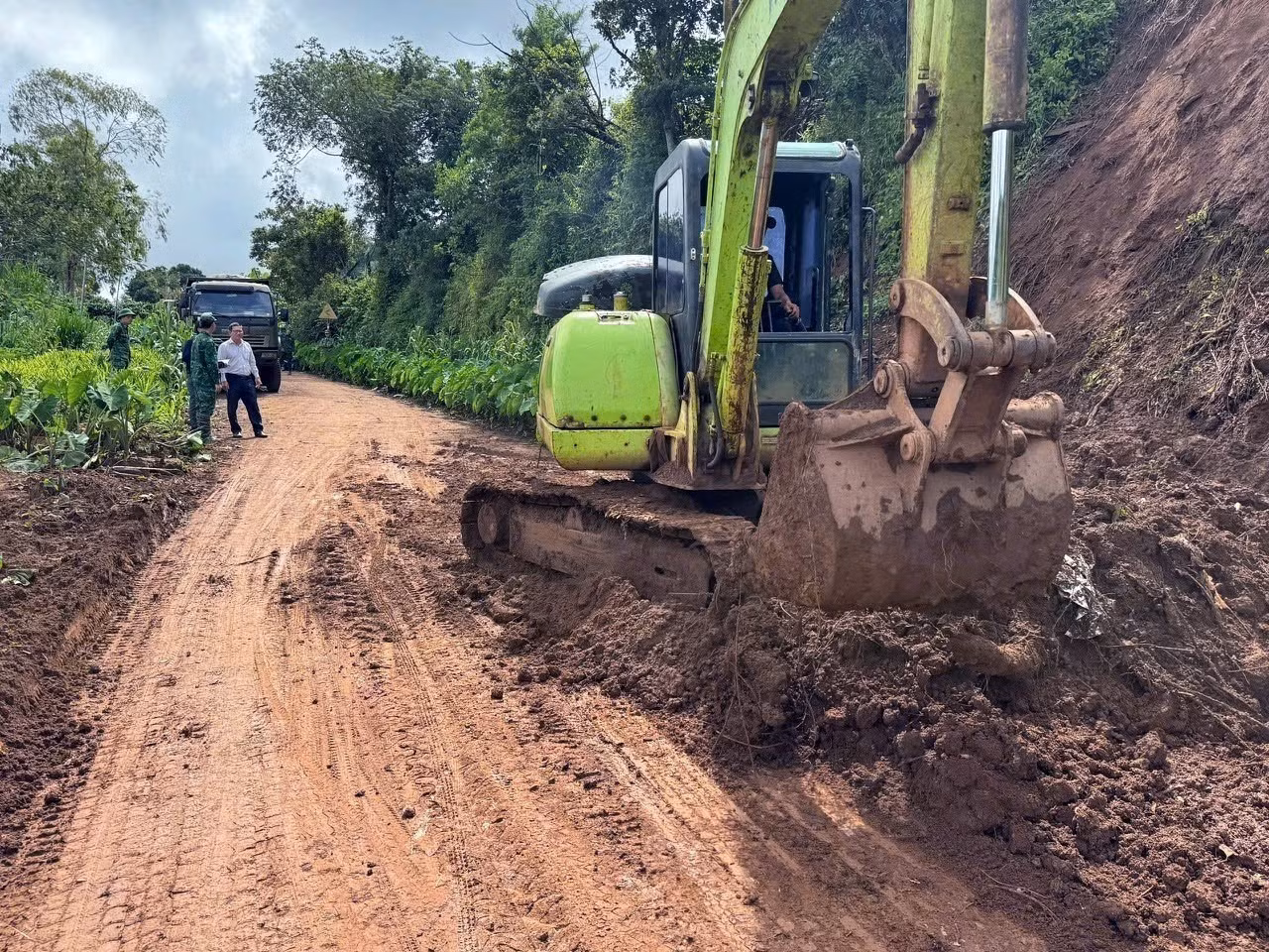 Thu dọn đất đá bị sạt lở xuống tuyến đường huyết mạch tại thôn Thuận Nam, xã Thuận An, tỉnh Lâm Đồng. Ảnh: TTXVN phát