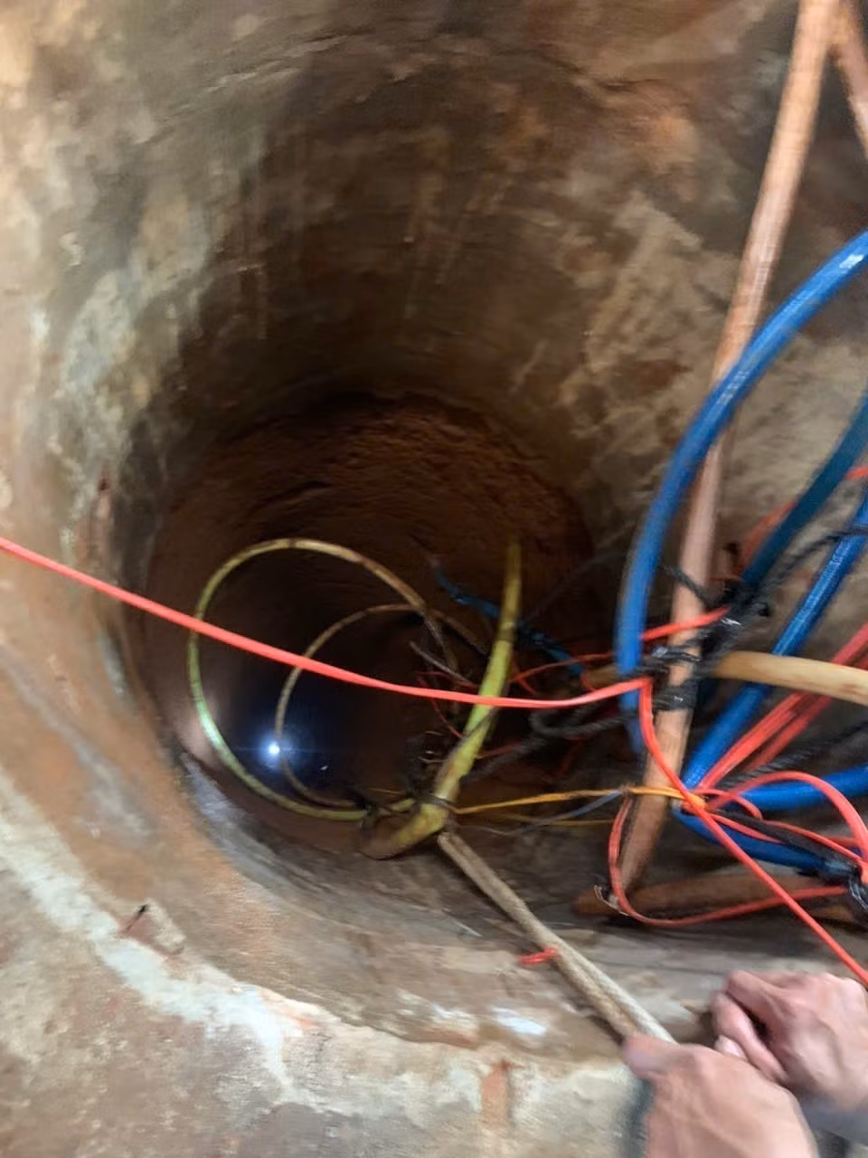 Các lực lượng chức năng của tỉnh Gia Lai đã nỗ lực giải cứu thành công hai nạn nhân bị rơi xuống giếng sâu lên mặt đất an toàn. Ảnh: TTXVN phát