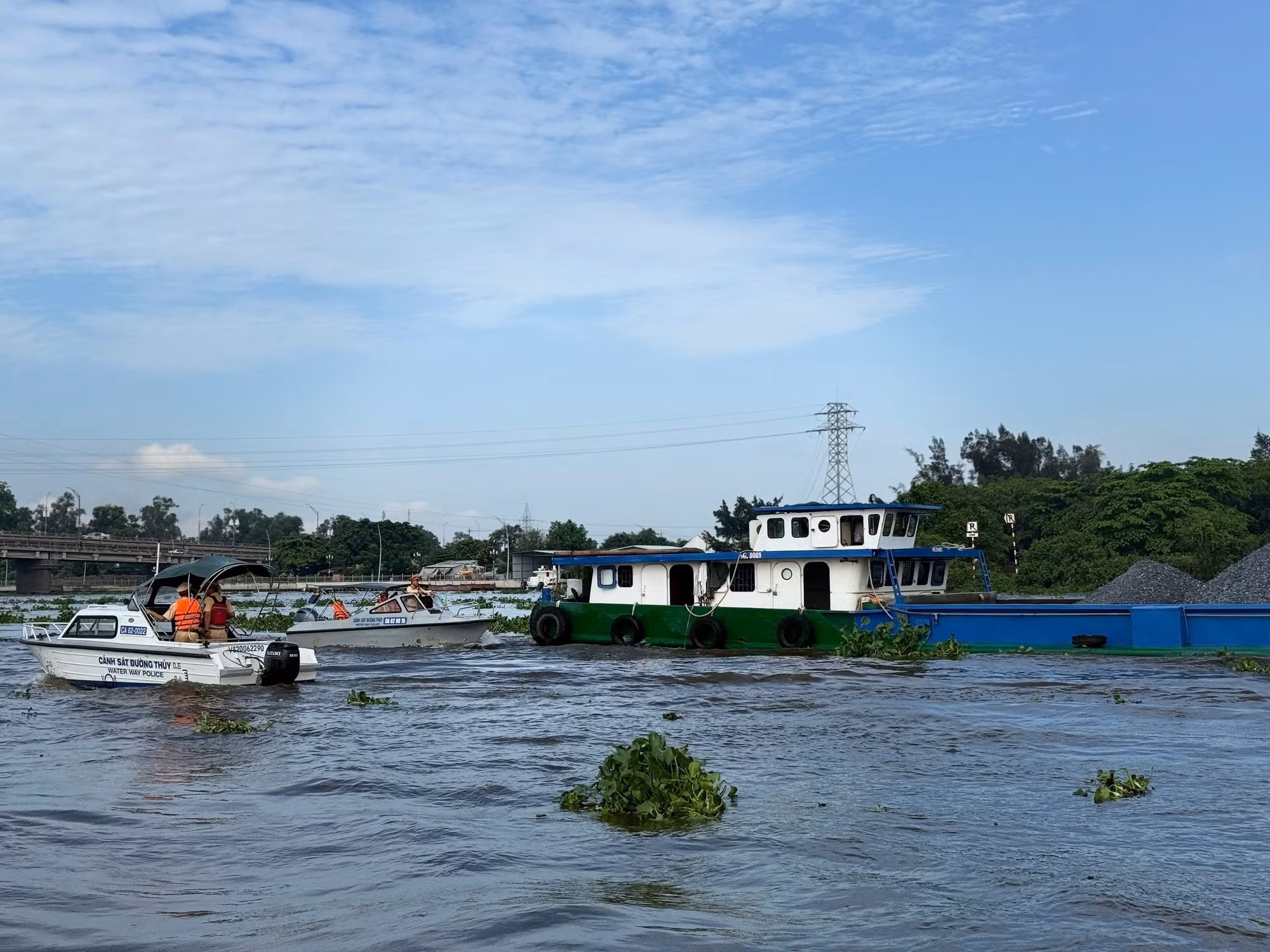 Lực lượng Cảnh sát đường thủy Long An kiểm tra chủ phương tiện vận chuyển khoáng sản trên sông Vàm Cỏ Đông. Ảnh: TTXVN phát