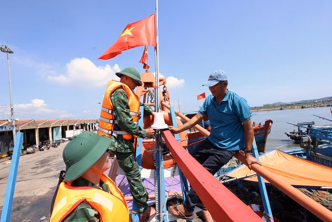 Bộ đội Biên phòng Hải Hoà tặng cờ Tổ quốc cho chủ tàu cá Nguyễn Văn Chiến chuẩn bị ra khơi khai thác thuỷ sản, tại cảng cá Lạch Bạng, phường Hải Bình, tỉnh Thanh Hóa.