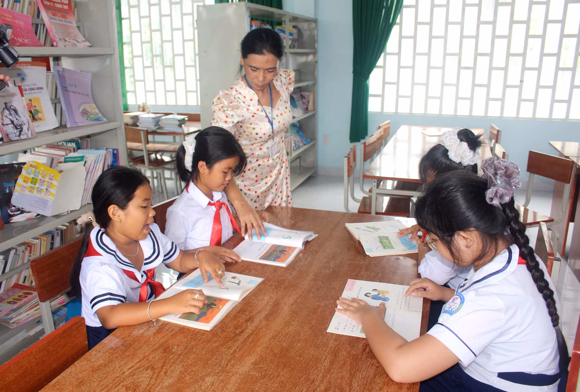 Học sinh tìm đọc thêm sách, ảnh tiếng Chăm tại thư viện Trường tiểu học Lâm Hưng, xã Hàm Thuận (tỉnh Lâm Đồng).