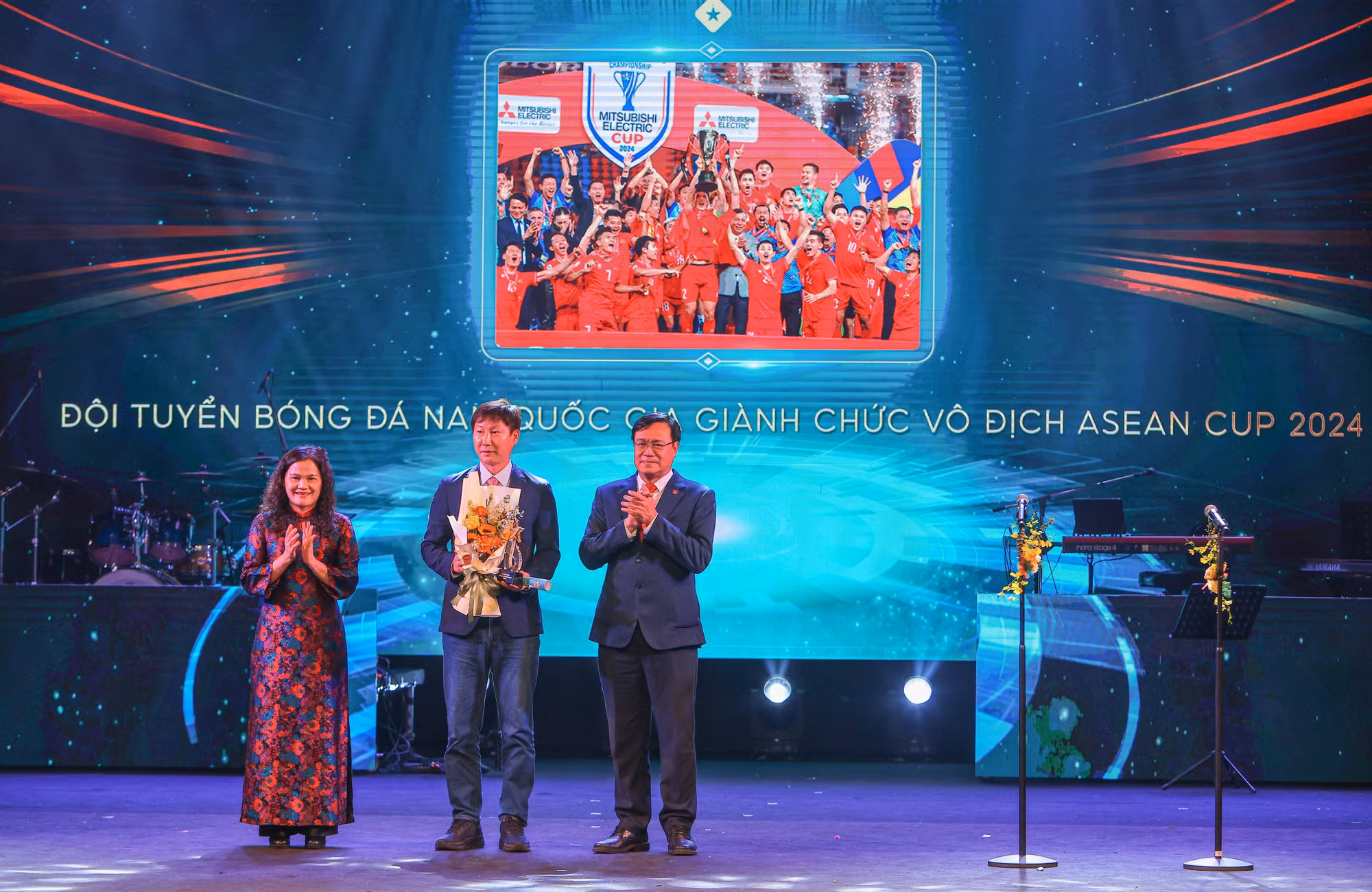 Phó Tổng Giám đốc TTXVN Nguyễn Thị Sự và Cục trưởng Cục thể dục thể thao Đặng Hà Việt trao “Chiến tích thể thao của năm” cho HLV Kim Sang Sik - đại diện đội tuyển bóng đá nam Việt Nam. Ảnh: Hoàng Hiếu - TTXVN