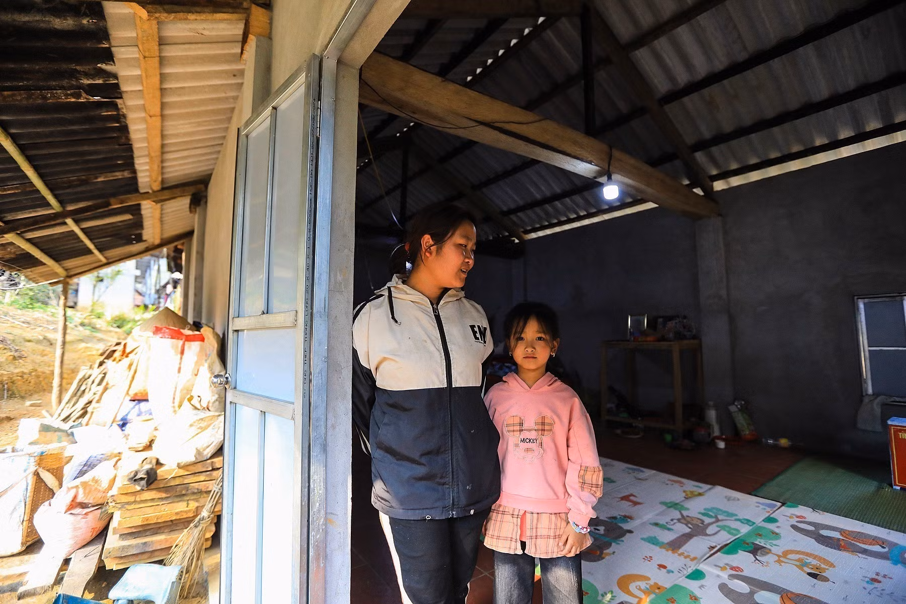 Hai con gái của hộ gia đình nghèo ông Vì Văn Sứ xóm Nàng xã Thành Sơn trong căn nhà mới xây thuộc Chương trình xóa nhà tạm, nhà dột nát. Ảnh: Trọng Đạt-TTXVN