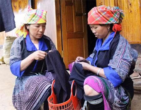 Tranh thủ những lúc rảnh rỗi, phụ nữ Mông thường may váy áo. Ảnh: Hoài Anh