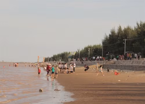 Du khách vui chơi, tắm biển tại bãi biển.