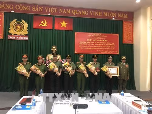 Thừa ủy quyền chủ Chủ tịch nước Cộng hòa DCND Lào, Thiếu tướng Búp Phả Si Phôm Ma, Thường vụ Đảng ủy Thủ đô, Giám đốc Công an thủ đô Viên Chăn trao Huân chương cho Công an Thành phố Hồ Chí Minh. Ảnh: Thành Chung - TTXVN.