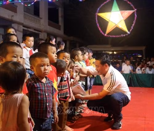 Nhà báo Xuân Sơn, đại diện Câu lạc bộ Liên quân báo chí Nghệ An tặng quà cho các em thiếu nhi xã Tam Hợp. Ảnh: TTXVN phát