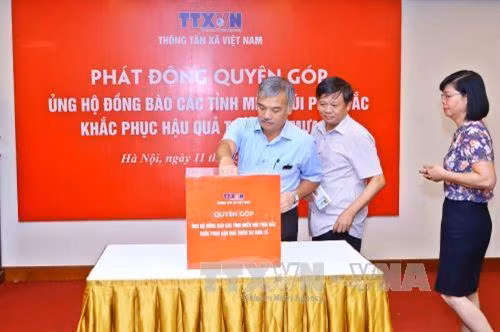 Các đồng chí lãnh đạo và cán bộ, phóng viên TTXVN quyên góp ủng hộ đồng bào các tỉnh Tây Bắc khắc phục thiệt hại do mưa lũ. Ảnh: Minh Quyết - TTXVN