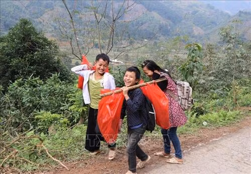 Học sinh trường Tiểu học và Trung học cơ sở số 2 xã Hồng Ca huyện Trấn Yên (Yên Bái) phấn khởi khi được các nhà tài trợ tặng áo ấm. Ảnh: Đinh Thùy-TTXVN