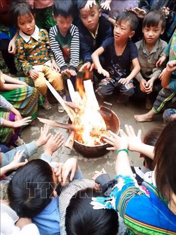 Các em học sinh trường Tiểu học và Trung học cơ sở số 2 xã Hồng Ca huyện Trấn Yên (Yên Bái) sưởi ấm trước khi vào lớp học. Ảnh: Đinh Thùy-TTXVN