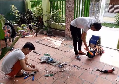 Nguyễn Hữu Thực và Trần Hoàng Nguyên chế tạo mô hình máy điều khiển tự động thu gom nông sản. Ảnh: Nguyễn Thành – TTXVN