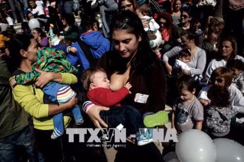 Các bà mẹ cho con bú tại Athens, Hy Lạp. AFP/TTXVN