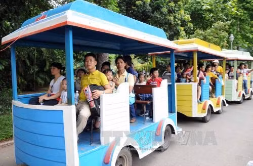 Người dân đi xe điện tham quan Thảo cầm Viên, Quận 1, Thành phố Hồ Chí Minh. Ảnh: An Hiếu – TTXVN.
