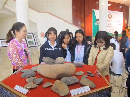 Các em học sinh nghe giới thiệu về các công cụ bằng đá thời tiền sử. Ảnh: Vũ Thị Hà - TTXVN