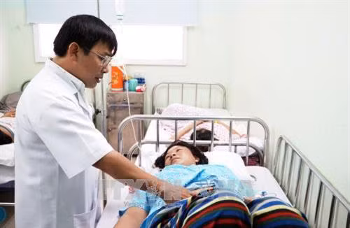 Bác sĩ bệnh viện Hùng Vương thăm khám cho sản phụ. Ảnh: Phương Vy-TTXVN