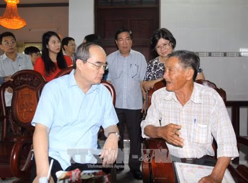 Bí thư Thành ủy Thành phố Hồ Chí Minh Nguyễn Thiện Nhân thăm hỏi hộ nông dân Nguyễn Văn Ron, ngụ tại 43 đường Hố Bò, ấp Phú Lợi, xã Phú Mỹ Hưng, huyện Củ Chi. Ảnh: Thanh Vũ-TTXVN