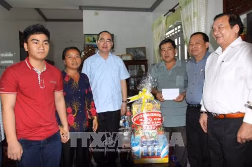 Bí thư Thành ủy Thành phố Hồ Chí Minh Nguyễn Thiện Nhân thăm hỏi, động viên và tặng quà hộ nông dân sản xuất giỏi Nguyễn Văn Tới, ngụ tại ấp Phú Lợi, xã Phú Mỹ Hưng, huyện Củ Chi. Ảnh: Thanh Vũ-TTXVN