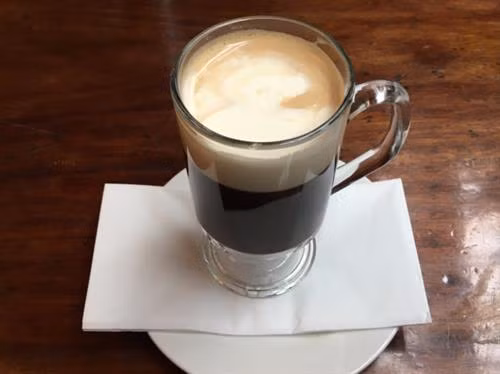Cà phê Kaffeost ở Phần Lan: Cà phê nóng cùng với những viên phô mai nhỏ. (ảnh: Youtube/bilboteket) Cà phê Türk Kahvesi ở Thổ Nhĩ Kỳ: Cà phê được pha bằng một dụng cụ bằng đồng đặc biệt gọi là cezve. Đặc biệt, với cách pha này, người ta không lọc bã cà phê mà để bã tự lắng xuống. (ảnh: Wikimedia). Cà phê Yuanyang ở Malaysia: Một loại thức uống cực ngon được pha chế từ 3 phần cà phê đen và 7 phần trà sữa Hongkong. Bạn có thể dùng loại đồ uống này nóng hoặc lạnh. (ảnh: Courtesy of The Works of Life). Cà phê Flat White ở Australia: Loại cà phê này tương tự như cách làm một ly latte nhưng với kích cỡ nhỏ hơn. Để làm một tách này bạn cần một shot espresso và phun bọt sữa lên trên. (ảnh: Flick/Jessica Spengler). Cà phê Frappé ở Hy Lạp: Đây là đồ uống do một đại diện của hãng Nescafé tạo ra năm 1957. Loại cà phê này khá phổ biến vào mùa hè ở Hy Lạp, bao gồm cà phê hòa tan và lớp bọt sữa ở bên trên. (ảnh: Shutterstock). Cà phê Espresso Romano ở Italy: Người Italy dùng Espresso cùng với một lát chanh, thứ có thể mang lại hương vị độc đáo cho tách cà phê này. (ảnh: Shutterstock). Cà phê sữa đá ở Việt Nam: Ngọt ngào và có hương vị mạnh mẽ, cà phê sữa đá rất phổ biến ở Việt Nam. Cà phê được ủ bằng phin và nhỏ giọt xuống một cốc chứa đá lạnh và sữa đặc ở bên dưới. (ảnh: Flick/Alpha) Cà phê Café de Olla của Mexico: Cà phê truyền thống Mexico được pha cùng với thanh quế và đường mía chưa tinh chế, sau đó được rót vào một chiếc cốc bằng đất sét. Người dân Mexico tin rằng cốc đất sét sẽ làm nổi bật hương vị cà phê hơn. (ảnh: Wikimedia). Cà phê Touba ở Senegal: Hạt cà phê được rang cùng với hạt tiêu Guinea và thảo mộc, sau đó được pha và lọc trực tiếp từ bình. (ảnh: Getty). Cafezinho ở Brazil: Đây là thức uống phổ biến nhất đối với người dân địa phương. Cafezinho tương tự như một tách espresso, chỉ có điều loại này ngọt và thường được ủ thẳng với đường. (ảnh: Shutterstock). Cà phê Bombon ở Tây Ban Nha dành cho những tín đồ "ưa ngọt" đích thực với một lớp sữa đặc khá dày ở bên dưới cốc. (ảnh: Flickr/Abel Pardo Lopez). Cà phê Irish ở Ireland là một hỗn hợp bao gồm cà phê nóng, whisky Ailen, và đường, cùng với một lớp kem dày bên trên. (ảnh: Flickr/Marco Verch). Cà phê Wiener Melange ở Áo: Tương tự như cappuccino, thức uống này bao gồm espresso ở dưới cốc, ở trên phủ lớp sữa, bọt sữa, đôi khi có cả kem và bột ca cao. (ảnh: Shutterstock). Café au lait ở Pháp: Người Pháp thường thích khởi đầu ngày mới bằng ly cà phê hòa cùng với sữa nóng với tỷ lệ bằng nhau. Cà phê thường được rót trong một chiếc cốc lớn để có thể nhúng bánh croissant. (ảnh: Flickr/Christopher Cornelius). Cà phê Spiced của Morocco: Cà phê đen được pha trộn cùng với các loại gia vị nóng như thảo quả, hạt tiêu đen, quế, đinh hương, và nhục đậu khấu. (ảnh: Shutterstock). Cà phê Cubano của Cuba mang hương vị mạnh mẽ của espresso pha với đường. (ảnh: Shutterstock).