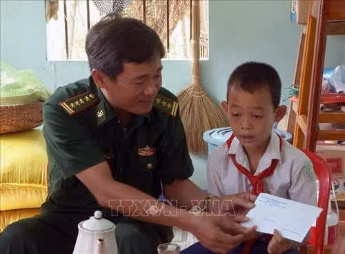 Đại tá Nguyễn Ngọc Minh, Chính ủy Bộ Chỉ huy Bộ đội Biên phòng tỉnh Phú Yên, trao tiền hỗ trợ cho học sinh. Ảnh: Thế Lập - TTXVN