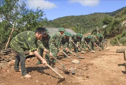Các chiến sĩ làm nền để dựng nhà cho người dân bản Huổi Chan 2. Ảnh: Xuân Tư – TTXVN