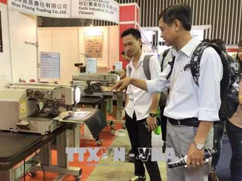 Khách hàng tìm hiểu thông tin về máy móc và các thiết bị chuyên ngành. Ảnh: Mỹ Phương - TTXVN