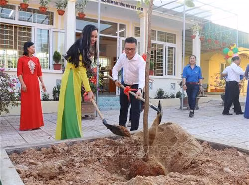 Phó Tổng giám đốc TTXVN Lê Quốc Minh trồng cây lưu niệm tại Trường THCS Đức Thành. Ảnh: Nguyễn Oanh-TTXVN