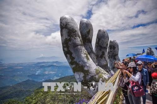 Cầu Vàng nằm giữa trời mây mang lại trải nghiệm thú vị cho những du khách đến tham quan, ngắm cảnh tại đây. Ảnh: Trọng Đạt - TTXVN Cầu Vàng là điểm du lịch mới của Đà Nẵng đã và đang rất nổi tiếng cả trong và ngoài nước. Ảnh: Trọng Đạt - TTXVN Cầu Vàng là điểm du lịch mới của Đà Nẵng đã và đang rất nổi tiếng cả trong và ngoài nước. Ảnh: Trọng Đạt - TTXVN Du khách đi bộ trên cầu như đi trên "dải lụa được nâng giữ bởi đôi tay của thần núi". Ảnh: Trọng Đạt - TTXVN Cầu Vàng nằm ở khu vực vườn Thiên Thai của Sun World Ba Na Hills. Cầu được kết nối với nhà ga Marseille và Bordeaux để đưa khách từ khu vực chân núi hay làng Pháp thăm vườn hoa. Giữa không trung, cây cầu như một "dải lụa" vàng rực rỡ. Ảnh: Trọng Đạt - TTXVN
