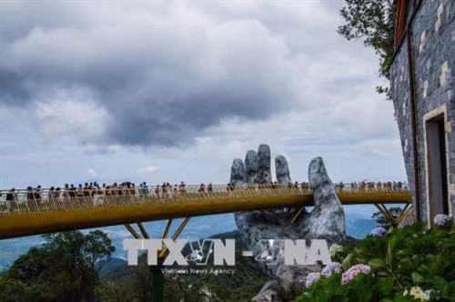 Cầu Vàng nằm giữa trời mây mang lại trải nghiệm thú vị cho những du khách đến tham quan, ngắm cảnh tại đây. Ảnh: Trọng Đạt - TTXVN Cầu Vàng là điểm du lịch mới của Đà Nẵng đã và đang rất nổi tiếng cả trong và ngoài nước. Ảnh: Trọng Đạt - TTXVN Cầu Vàng là điểm du lịch mới của Đà Nẵng đã và đang rất nổi tiếng cả trong và ngoài nước. Ảnh: Trọng Đạt - TTXVN Du khách đi bộ trên cầu như đi trên "dải lụa được nâng giữ bởi đôi tay của thần núi". Ảnh: Trọng Đạt - TTXVN Cầu Vàng nằm ở khu vực vườn Thiên Thai của Sun World Ba Na Hills. Cầu được kết nối với nhà ga Marseille và Bordeaux để đưa khách từ khu vực chân núi hay làng Pháp thăm vườn hoa. Giữa không trung, cây cầu như một "dải lụa" vàng rực rỡ. Ảnh: Trọng Đạt - TTXVN