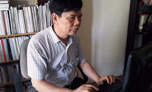 Nhà văn Dương Hướng miệt mài làm việc. Ảnh: Văn Đức - TTXVN