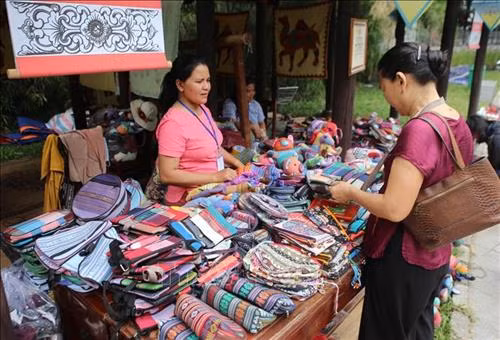 Không gian trưng bày, giới thiệu sản phẩm vải thổ cẩm. Ảnh: Hồ Cầu-TTXVN Du khách tham quan, mua sắm các sản phẩm làng nghề. Ảnh: Hồ Cầu-TTXVN