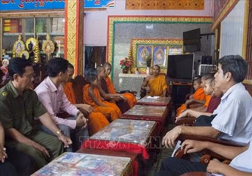 Đại đức Danh Pu (giữa) làm việc cùng chính quyền xã Thạnh Lộc, huyện Châu Thành. Ảnh: Hồng Đạt - TTXVN