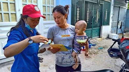 Cán bộ chuyên trách, tình nguyện viên Chữ thập đỏ thực hiện công tác truyền thông phòng, chống dịch bệnh sốt xuất huyết và virus Zika trên địa bàn khu dân cư Phường Bình Trị Đông, Quận Bình Tân ngay sau phát động lễ ra quân.Ảnh : Thế Anh-TTXVN