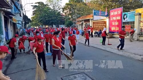 Cán bộ chuyên trách, tình nguyện viên Chữ thập đỏ tham gia dọn vệ sinh môi trường trên địa bàn Phường Bình Trị Đông, Quận Bình Tân ngay sau phát động lễ ra quân. Ảnh : Thế Anh-TTXVN