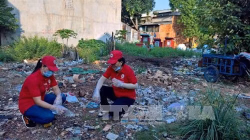 Cán bộ chuyên trách, tình nguyện viên Chữ thập đỏ thực hiện dọn vệ sinh môi trường trên địa bàn Phường Bình Trị Đông, Quận Bình Tân ngay sau phát động lễ ra quân. Ảnh : Thế Anh-TTXVN