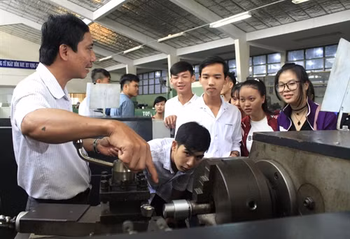 Học sinh tham quan và nghe giới thiệu về các thiết bị, mô hình đồ dùng dạy học do giảng viên, sinh viên của trường tự thiết kế. Ảnh: Lê Thúy Hằng - TTXVN