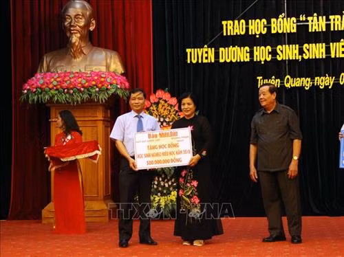 Đại diện Báo Nhân Dân trao trao 100 suất học bổng tổng trị giá 300 triệu đồng cho Quỹ khuyến học tỉnh Tuyên Quang. Ảnh: Quang Cường – TTXVN