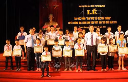 Lãnh đạo tỉnh Tuyên Quang và các nhà tài trợ khen thưởng học sinh, sinh viên vượt khó tiêu biểu năm học 2018. Ảnh: Quang Cường – TTXVN