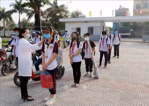 Học sinh trường chuyên Biên Hòa (thành phố Phủ Lý, tỉnh Hà Nam) được kiểm tra thân nhiệt trước khi vào lớp. Ảnh: Đại Nghĩa- TTXVN