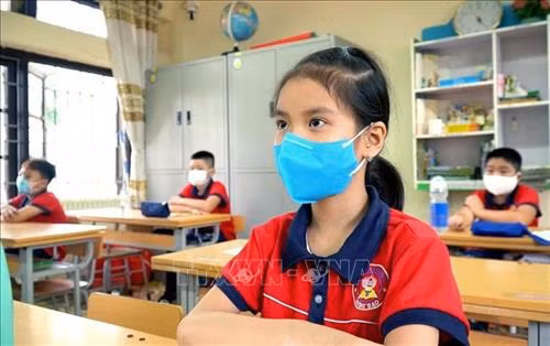 Ngày đầu tiên học sinh Quảng Ninh đi học trở lại phải đeo khẩu trang trong lớp. Ảnh: TTXVN