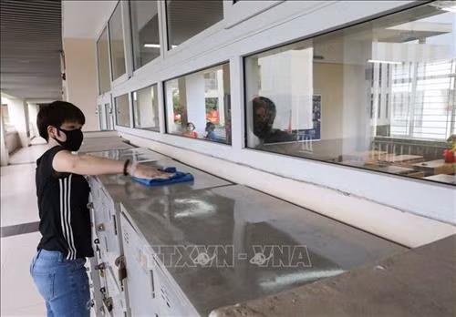 Phụ huynh cùng giáo viên Trường THCS Nghĩa Tân, quận Cầu Giấy tiến hành vệ sinh, khử khuẩn toàn bộ trường học, sẵn sàng đón học sinh trở lại trường từ 4/5. Ảnh: Thanh Tùng - TTXVN