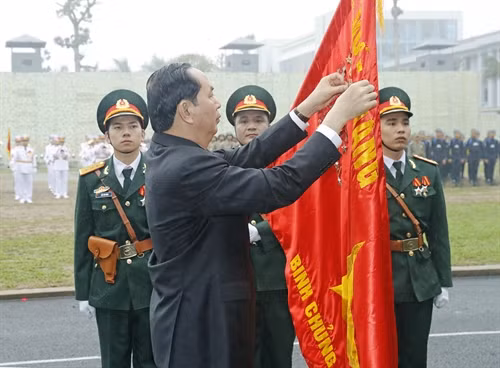 Chủ tịch nước Trần Đại Quang gắn Huân chương Quân công hạng Nhất lên lá cờ truyền thống của Bộ Tư lệnh Binh chủng Đặc công. Ảnh: Nhan Sáng-TTXVN